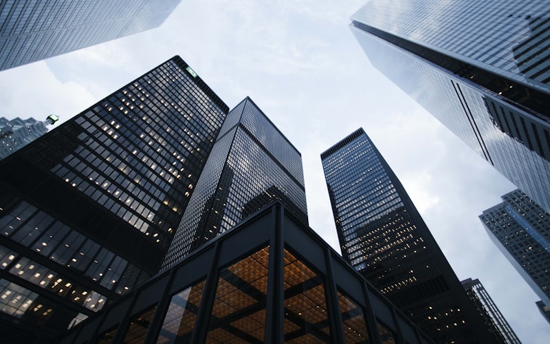 Glass office towers photographed from street level against an overcast sky